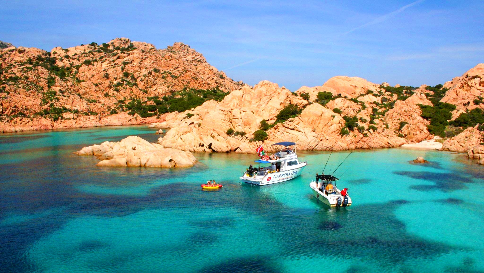 La barca di Orso Diving Club Poltu Quatu sta per gettare l'ancora vicino ad una spiaggia, durante il giro in barca dell'isola di Caprera.