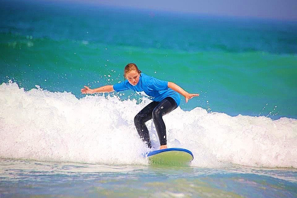 A girl faces the waves while surfing in Anglet.