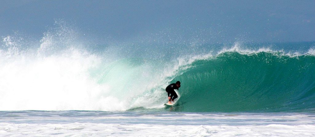 A boy faces the waves while surfing in Anglet.