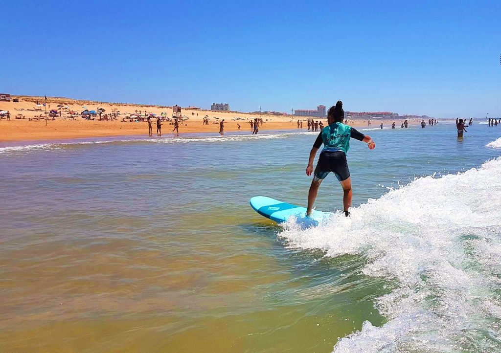 A girl is riding the waves during one of her surfing lessons in Hossegor. 