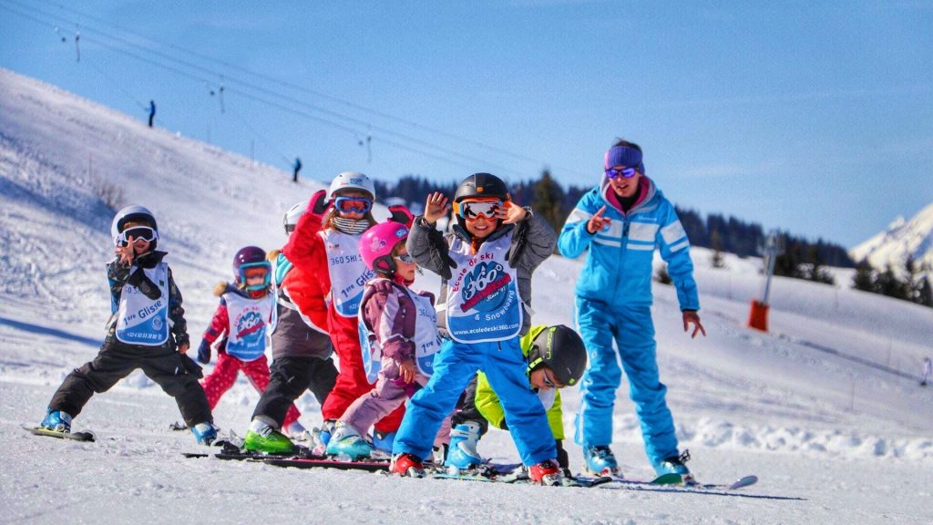 A group of children learn to ski in Les Gets with the help of an instructor.