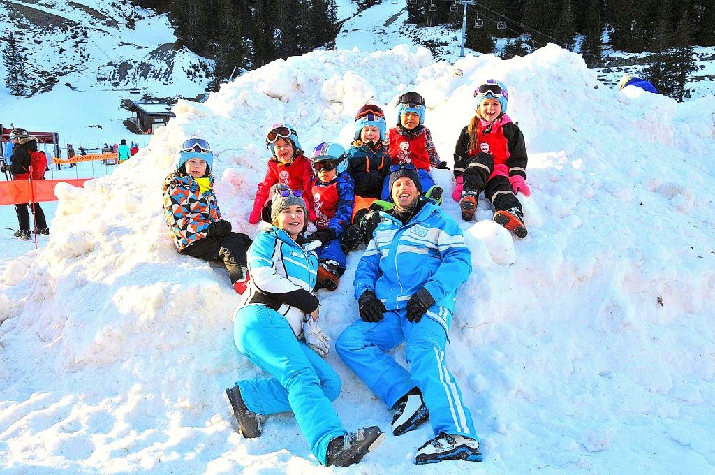 Children pose for a photo with the instructors, group training is the best way to learn to ski in Morzine.