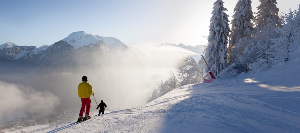 A boy learns to ski in Morzine helped by a ski instructor.