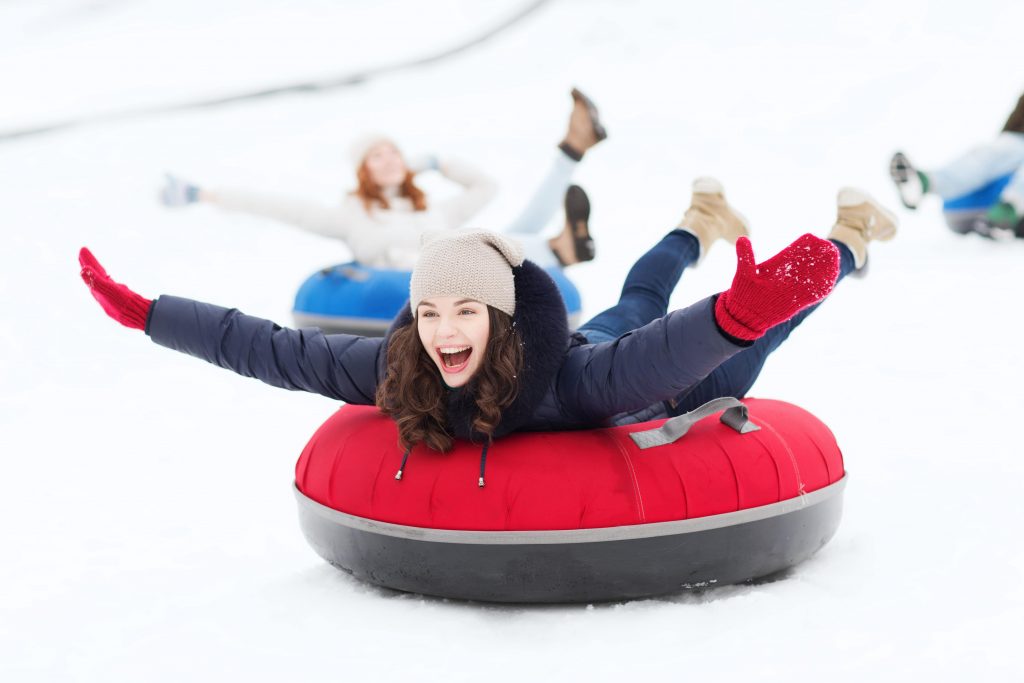 Après des heures passés sur les pistes pour apprendre à skier à Morzine, des jeunes femmes s’amusent en faisant du snowtubing.
