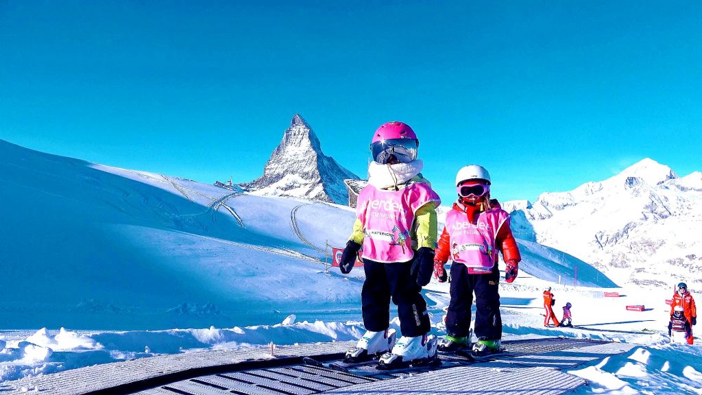 Two children learn to ski in Zermatt with the help of the magic carpet.