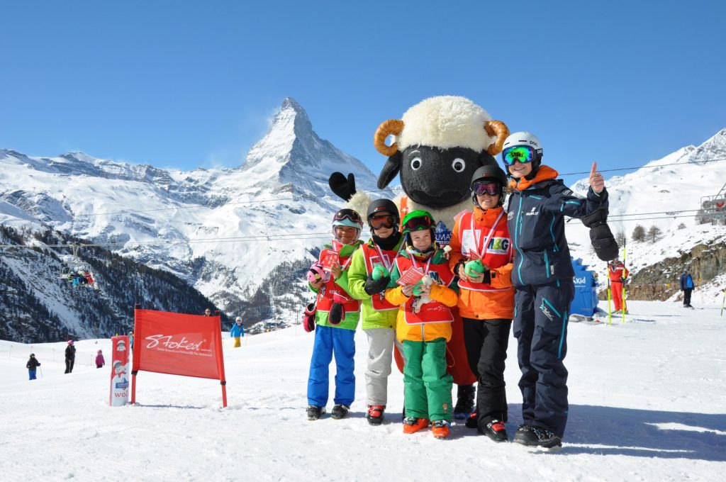 After a fun week, the kids learned to ski in Zermatt and now they enjoy a medal and a lot of fun with the mascot. 