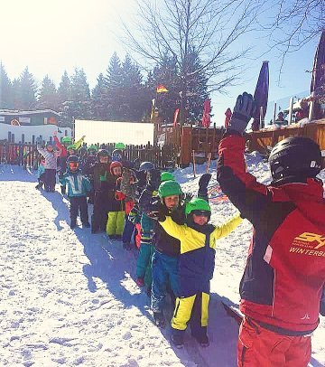 The children are in line and watch the ski instructor, everyone is ready to learn how to ski in Winterberg.