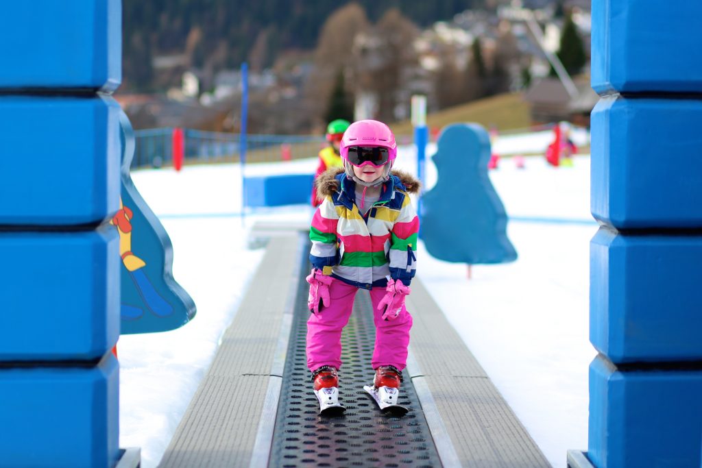 Children use the magic carpet during a ski lesson.