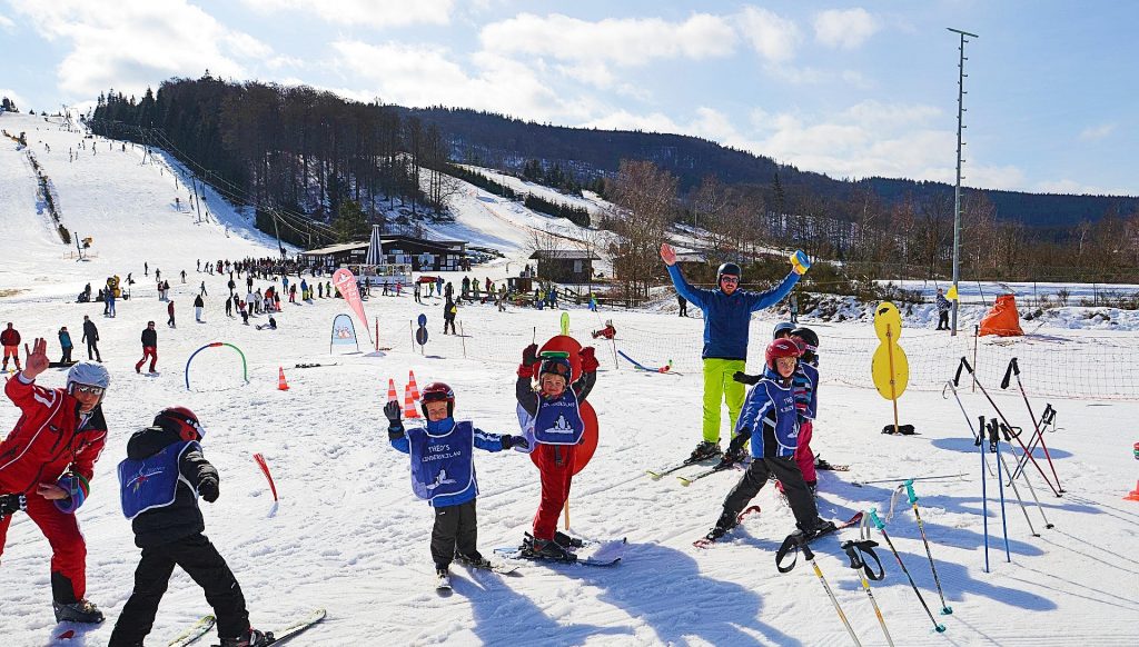 Children have fun in the kinderland while learning to ski in Winterberg.