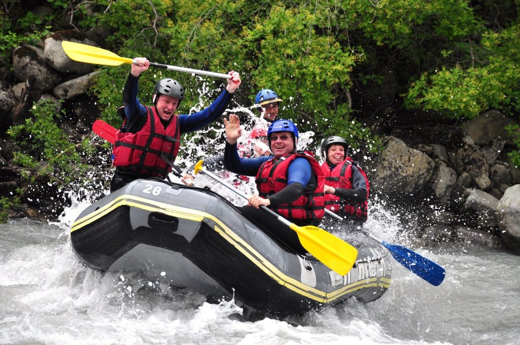 Eine Gruppe bewältigt auf ihrem Raft eine Stromschnelle.