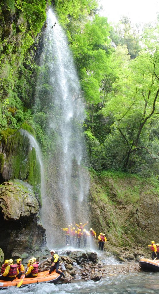 Eine Gruppe von Raftern genießt eine Pause bei einem Wasserfall. 