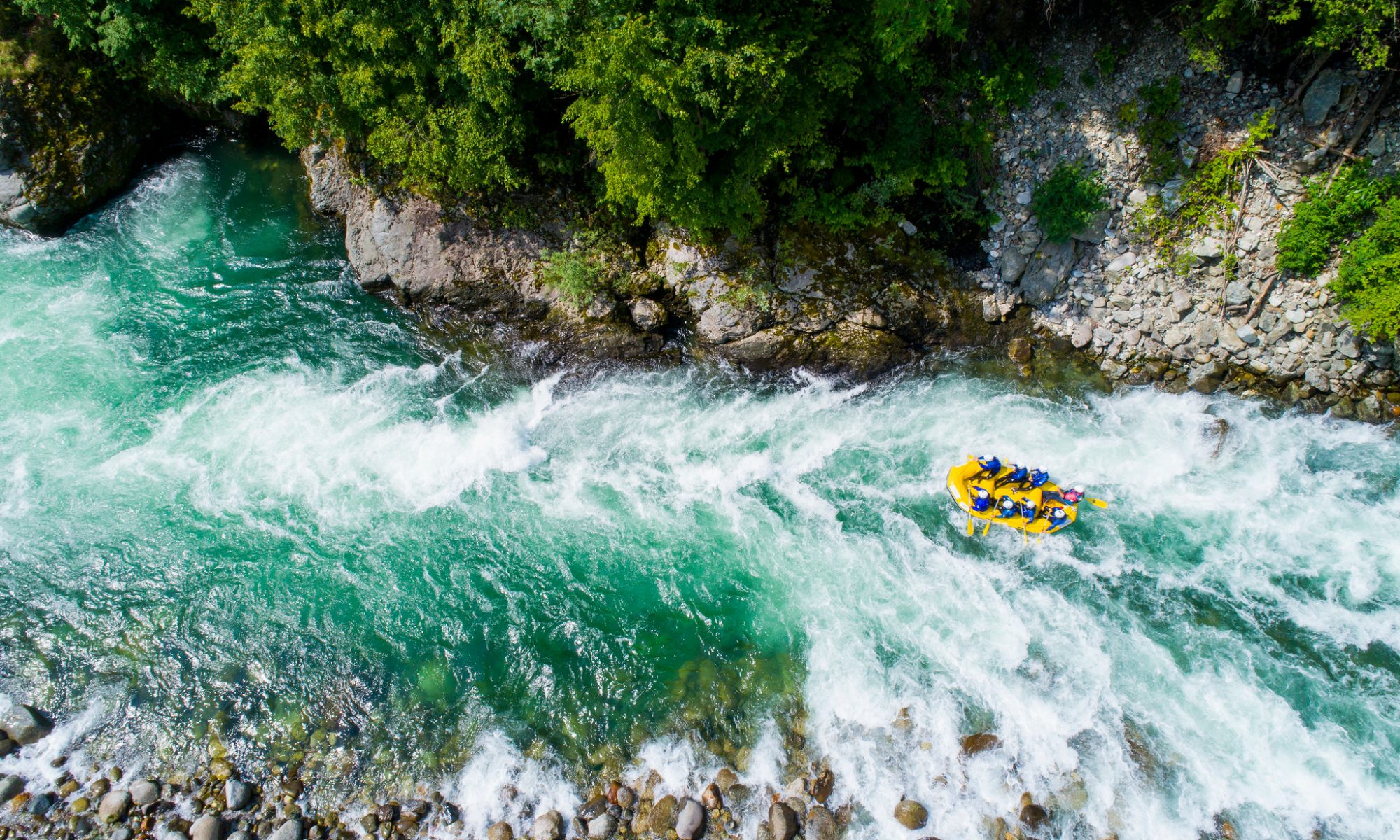 Eine Rafting-Gruppe beim Bewältigen von Stromschnellen auf dem Sesia.