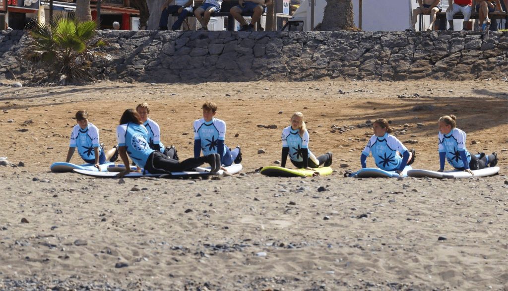 The participants of a surf course in Spain train on the beach. 