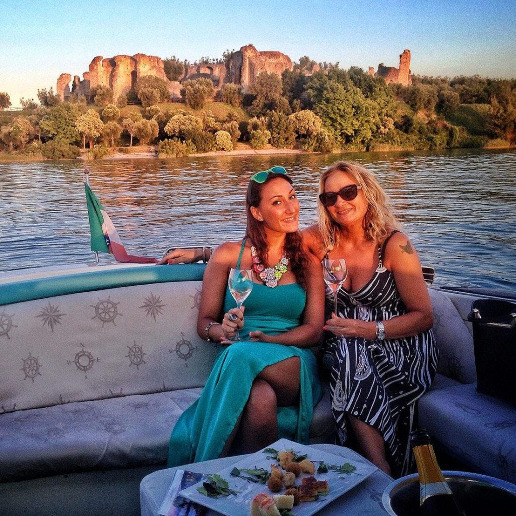 Due donne si godono il tramonto durante un giro in barca al Lago di Garda.