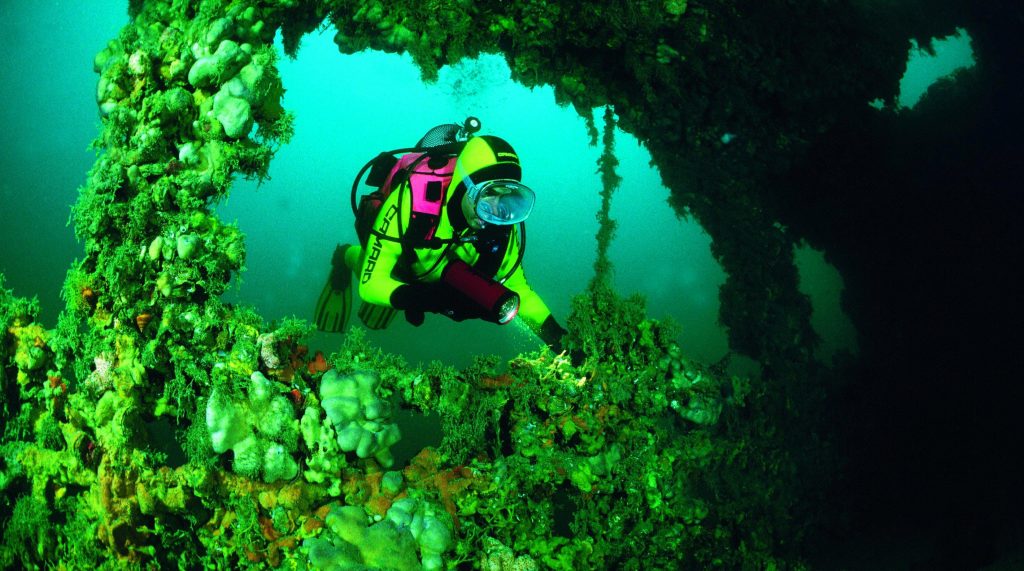 Un sommozzatore esplora un relitto di nave in Istria, il relitto nel mare Adriatico è ora l'habitat di numerosi animali marini.
