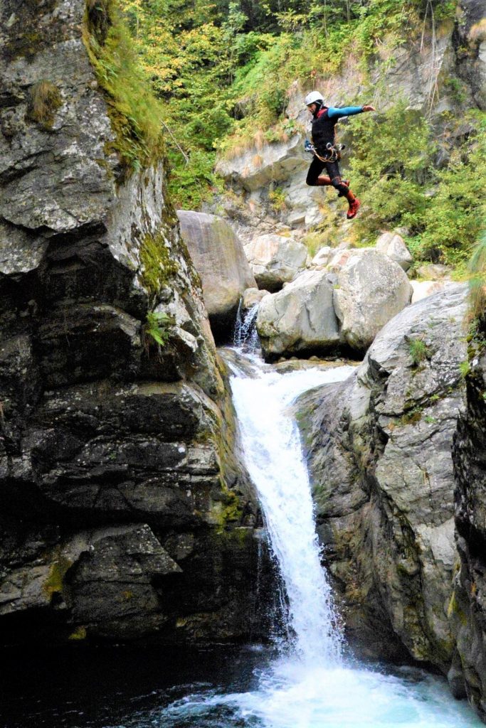 A participant in the canyoning excursion in the Sorba jumps in the water.