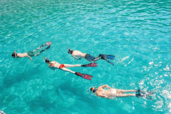People have fun snorkeling during a snorkeling trip in the marine reserva of Illes de Malgrets.