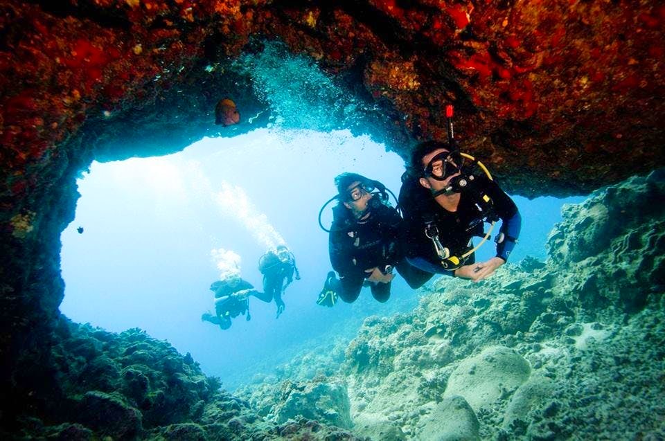 A group of divers exploring a cave while scuba diving in Spain.