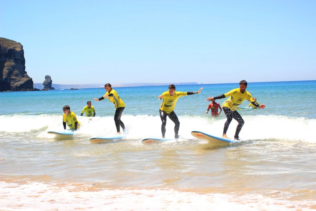 A group of beginners are surfing in Portugal,on a beach in Arrifana.