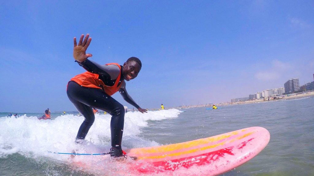 A boy is having fun while surfing in Portugal.