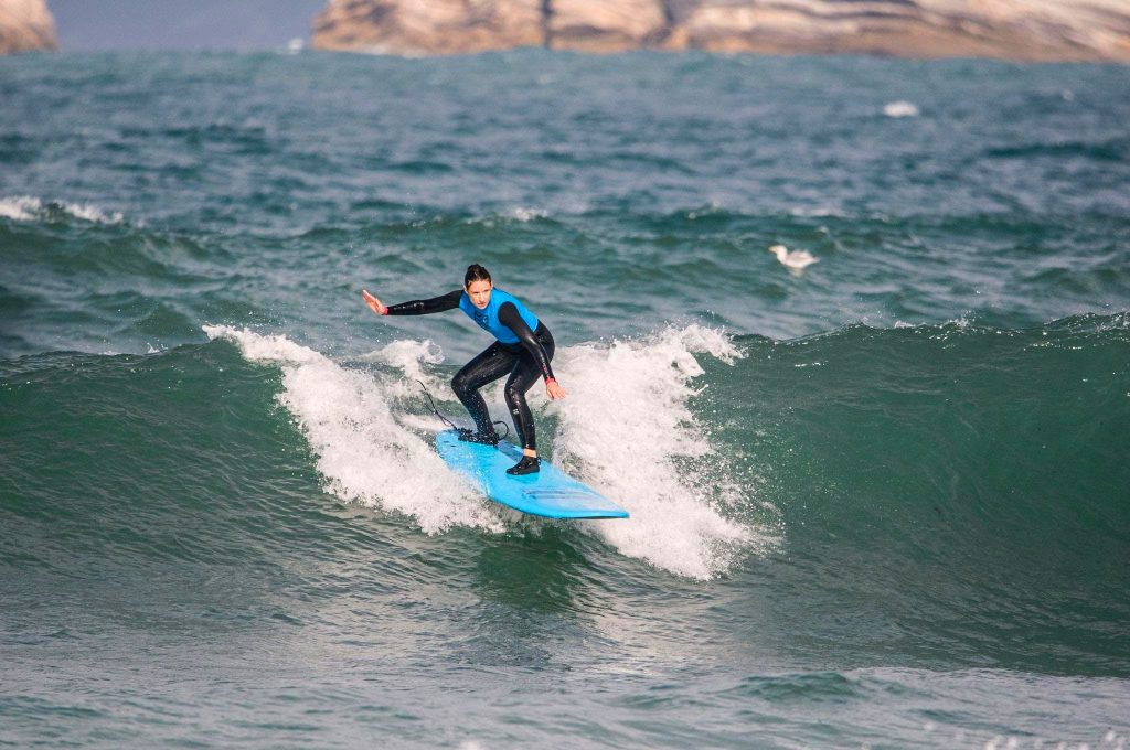 A young girl surfing in Portugal, on Gamboa Beach.