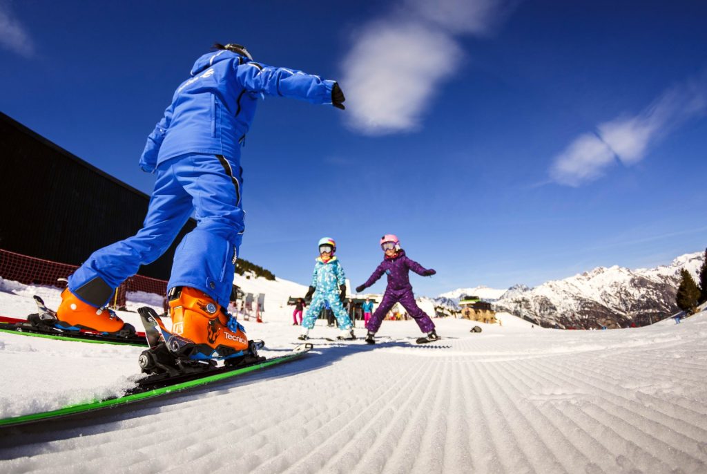 Two kids are learning how to ski in Aragon with a private ski instructor.