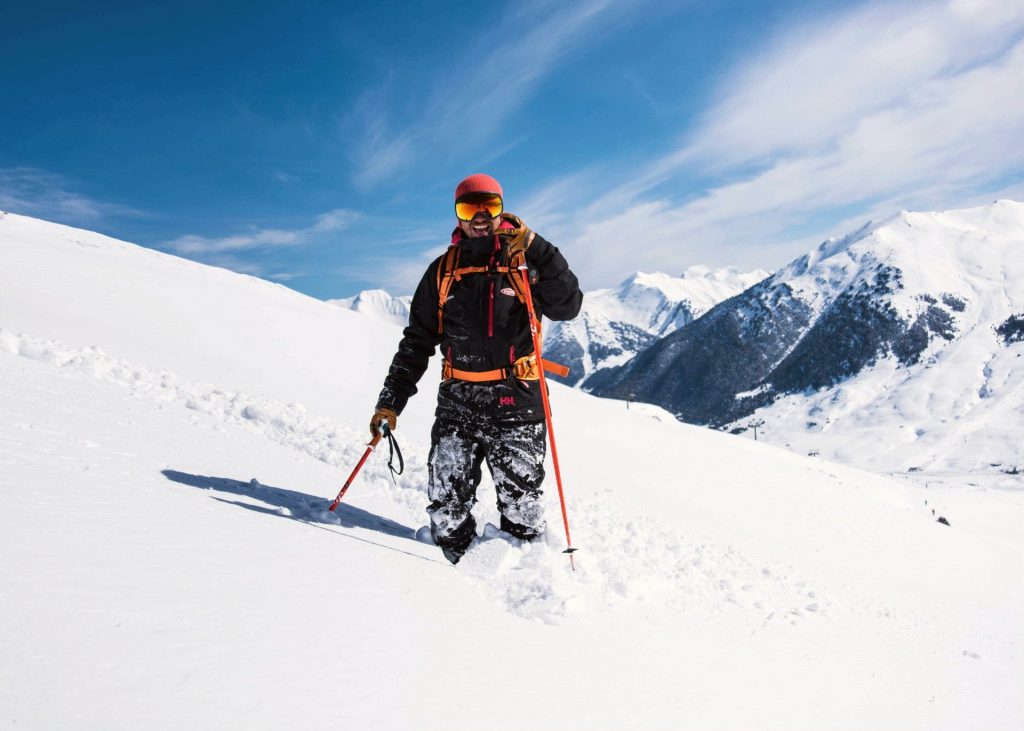 An off-piste skier is exploring the beautiful ski resorts in Spain. 