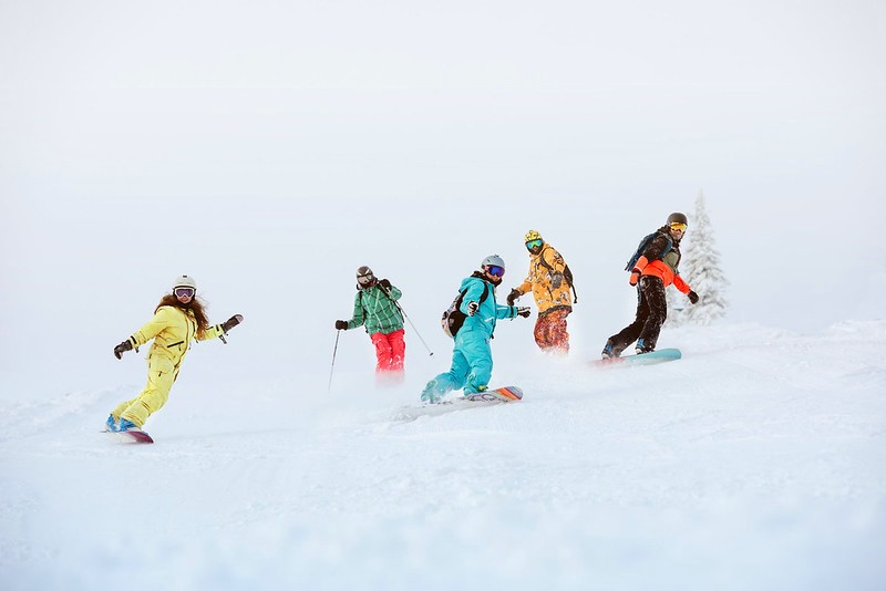 Einige Snowboarder nehmen an Gruppenkursen teil und lernen Snowboarden.
