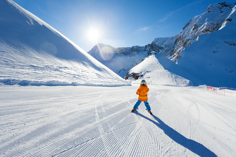 A little kid is skiing between France and Italy.