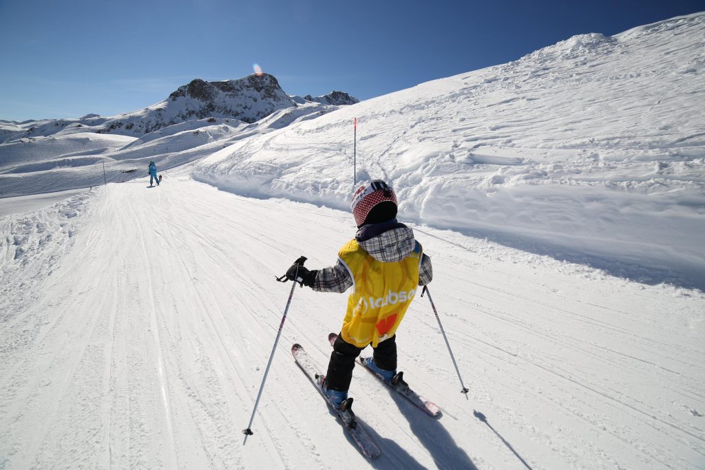 A youngster is exploring the slopes while skiing between France, Font Romeu, and Spain.