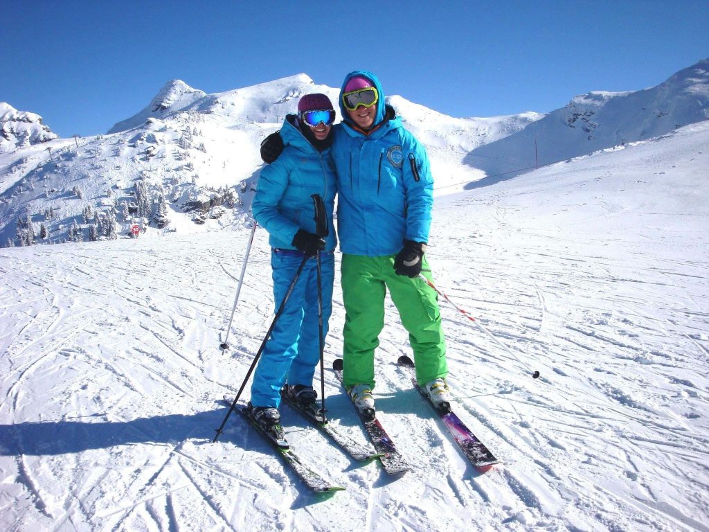 Two people are skiing between France, Portes du Soleil, and Switzerland.