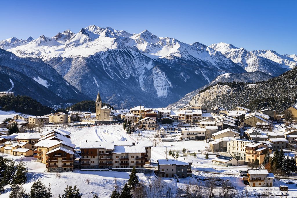 View of the wooden chalets and snowed streets of Aussois village in France. 