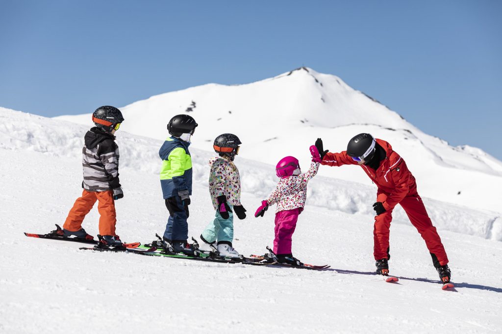 Children learning how to ski during a group ski lesson.