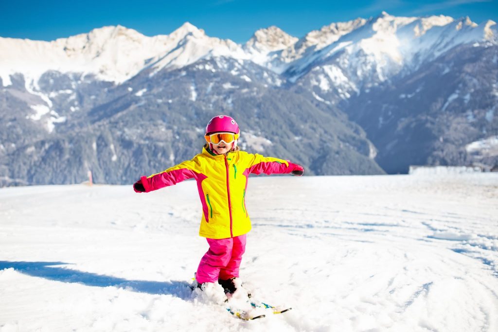 A young girl during a ski lesson for kids.