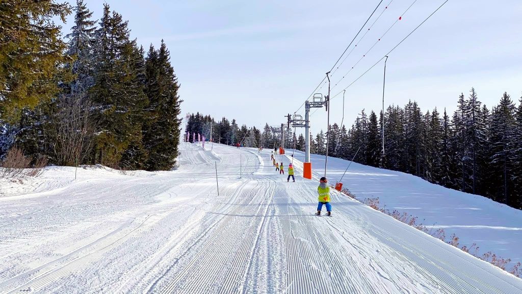 Des enfants apprennent à skier en France lors de leurs vacances de ski en famille.