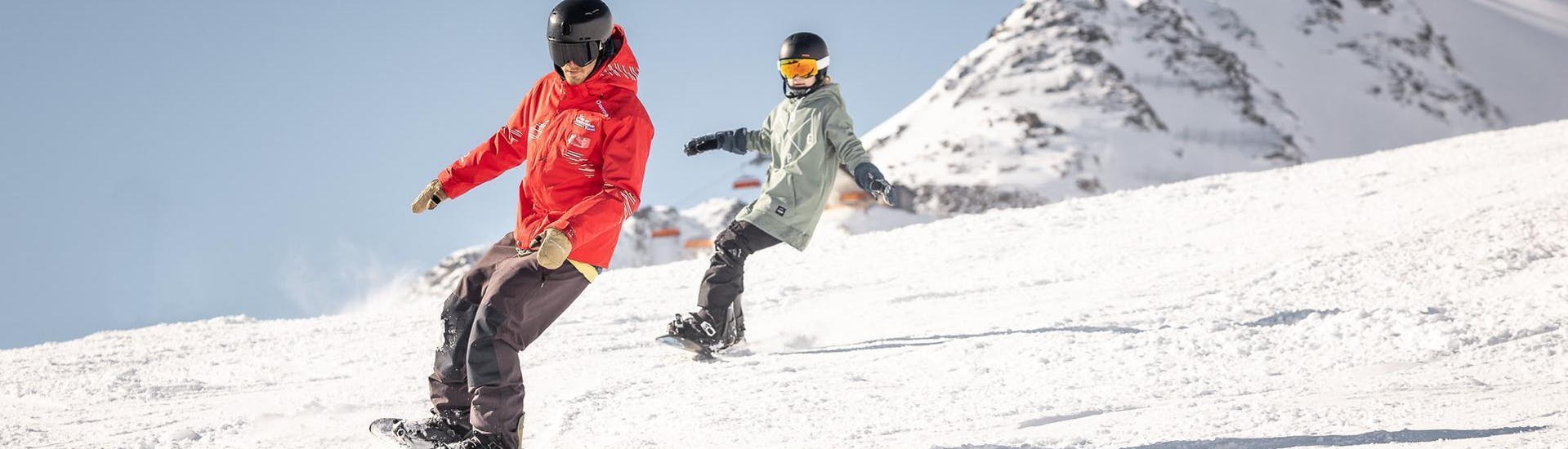 Een jongen leert snowboarden in Sölden in Oostenrijk.