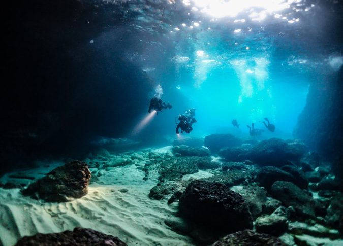A group of divers is exploring the seabed that you can find in Corfu.