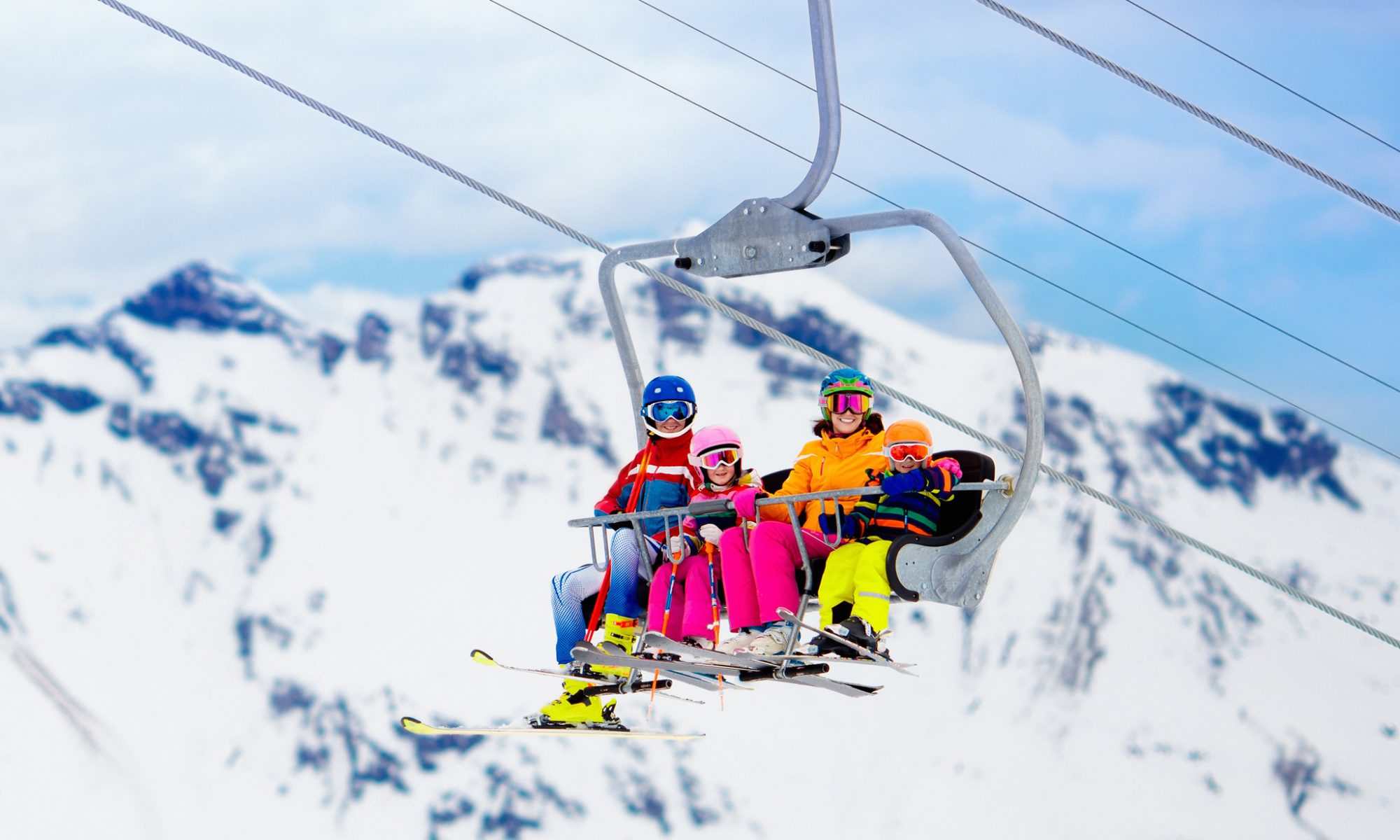 A family on a chair lift skiing in spring.