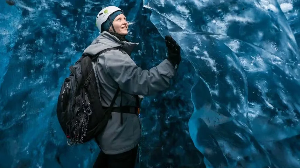 A woman touching the ice in an Ice Cave.
