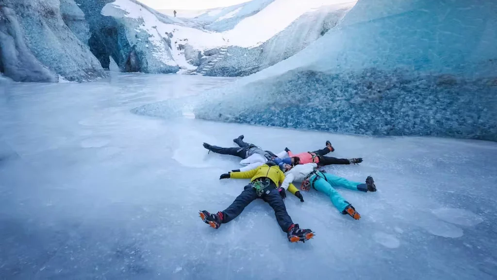 A family lying on a glacier forming a snowflake.