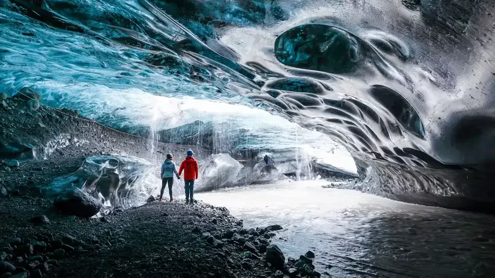 Two people inside the Sapphire Ice Cave.