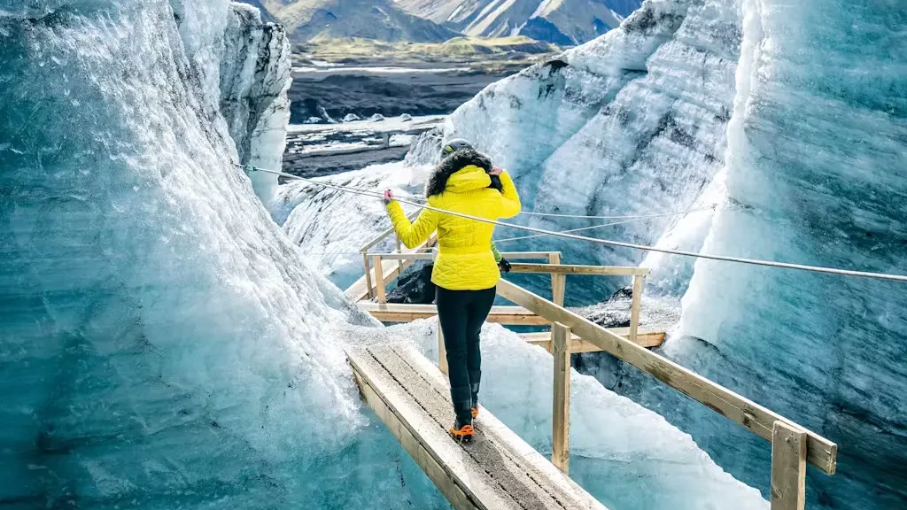 A woman crossing a glacier.