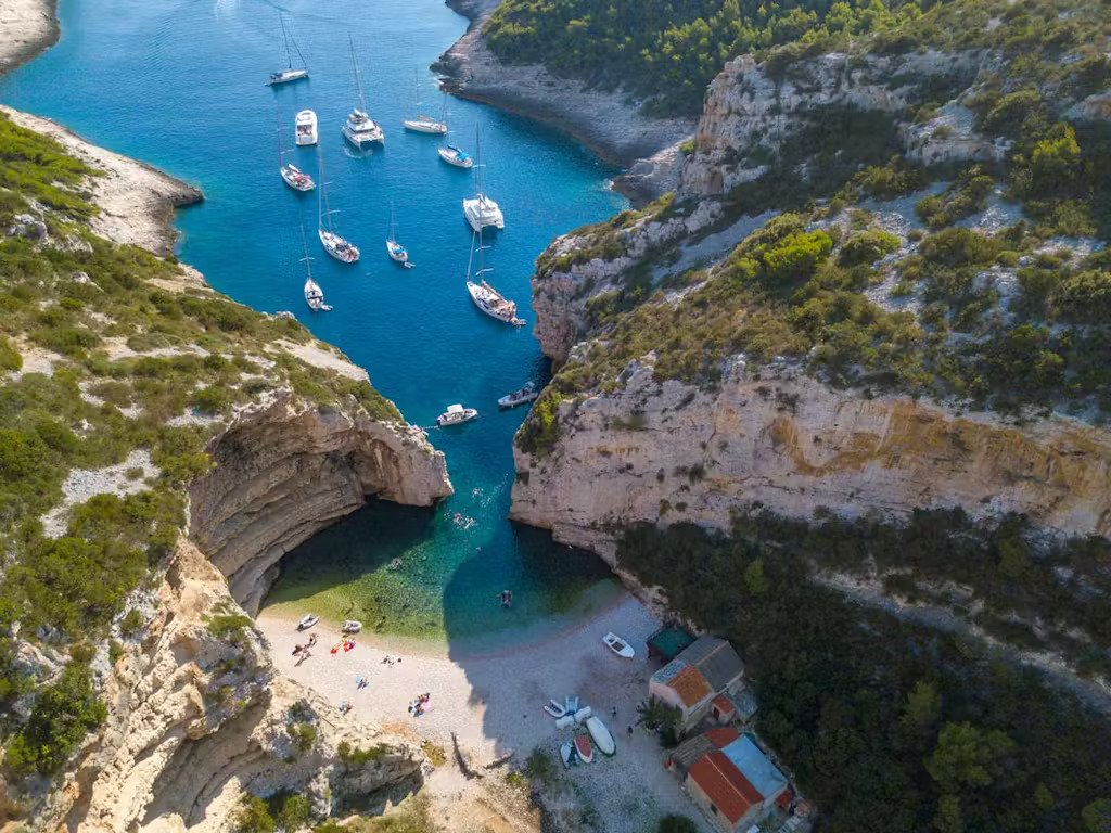 A stunning view of Hvar Island, Croatia, showcasing its vibrant coastline and lush greenery under a clear blue sky.