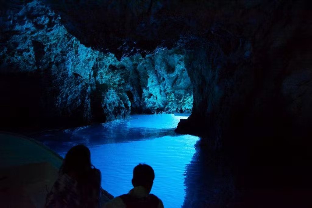 The enchanting Blue Cave in Croatia, featuring bright blue waters and rocky walls, creating a magical atmosphere.